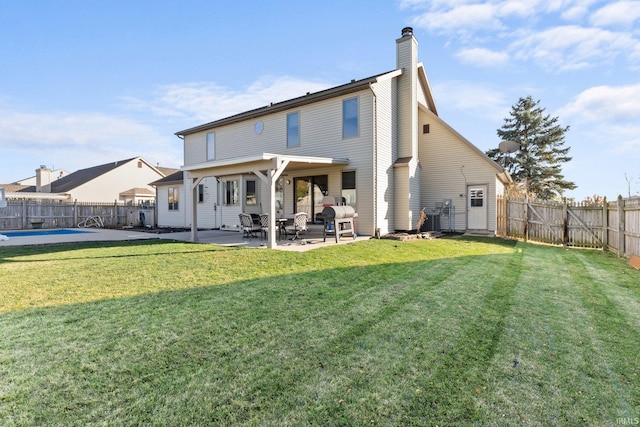 rear view of property featuring a yard and a patio area