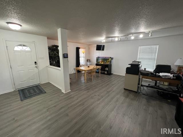 foyer entrance featuring rail lighting, dark hardwood / wood-style floors, and a textured ceiling