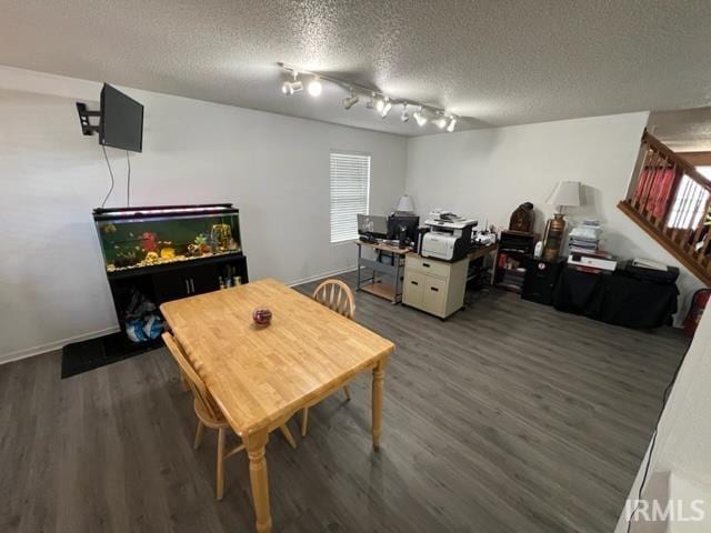 dining area with dark wood-type flooring and a textured ceiling