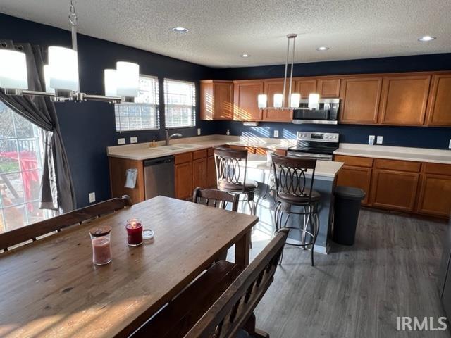 kitchen featuring pendant lighting, sink, dark wood-type flooring, appliances with stainless steel finishes, and a textured ceiling