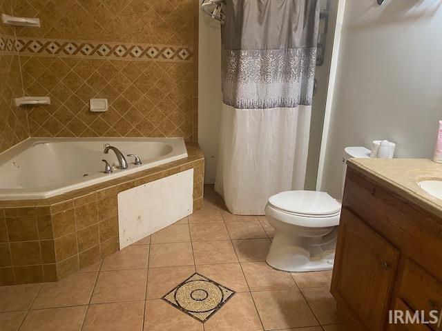 full bathroom with vanity, toilet, tile patterned flooring, and plus walk in shower