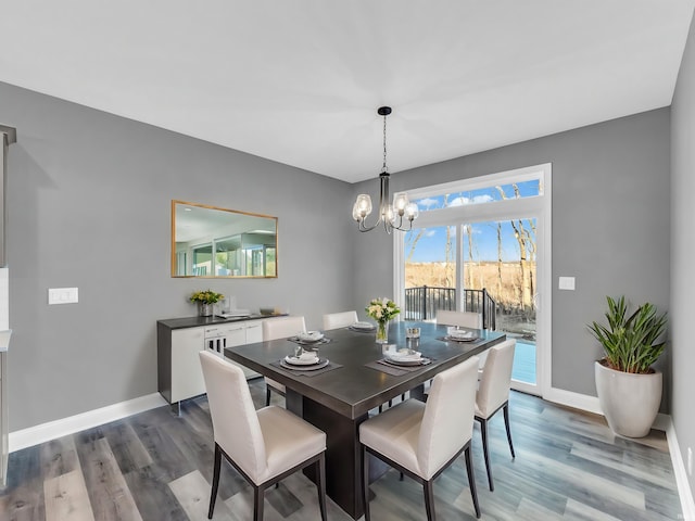 dining space featuring dark wood-type flooring and a notable chandelier