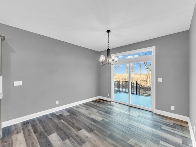 unfurnished dining area with dark hardwood / wood-style flooring and a notable chandelier