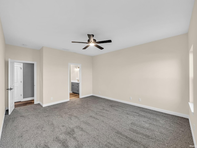 unfurnished bedroom with ensuite bath, carpet floors, and ceiling fan