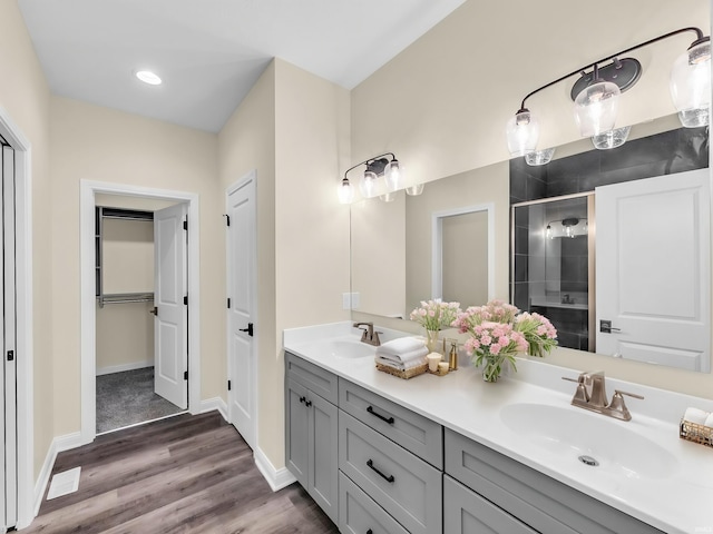 bathroom with vanity, hardwood / wood-style floors, and a shower with shower door