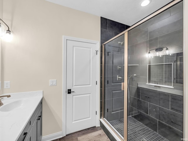 bathroom featuring hardwood / wood-style flooring, vanity, and an enclosed shower