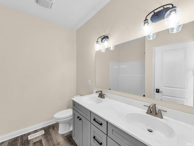 bathroom featuring vanity, toilet, and hardwood / wood-style floors