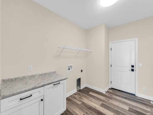 clothes washing area featuring hardwood / wood-style flooring, electric dryer hookup, washer hookup, and cabinets