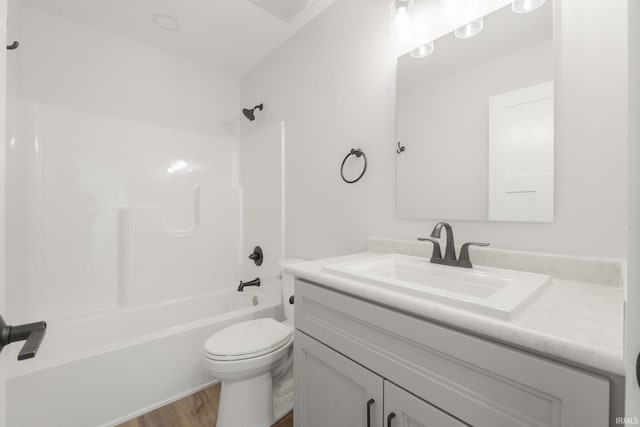 full bathroom with shower / washtub combination, toilet, hardwood / wood-style floors, and vanity