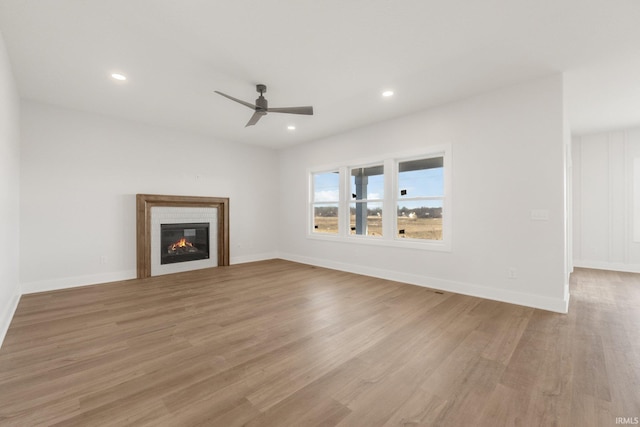 unfurnished living room with a fireplace, light hardwood / wood-style floors, and ceiling fan