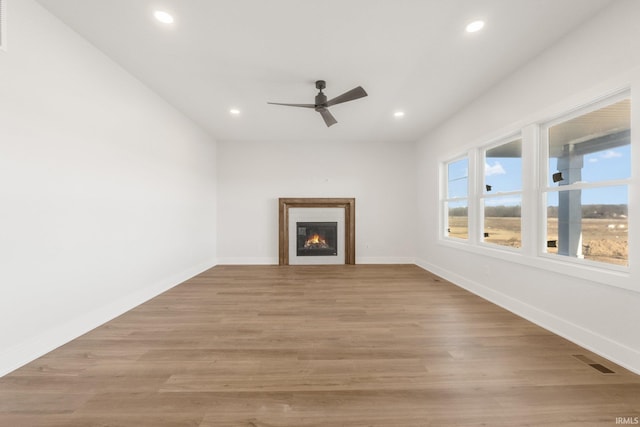 unfurnished living room featuring light hardwood / wood-style flooring and ceiling fan