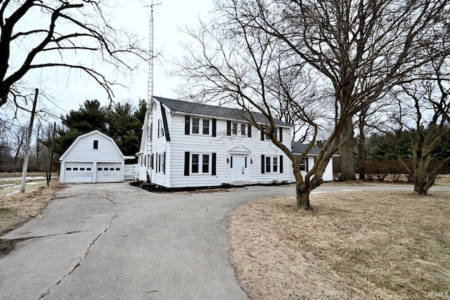 colonial inspired home with a garage and an outdoor structure