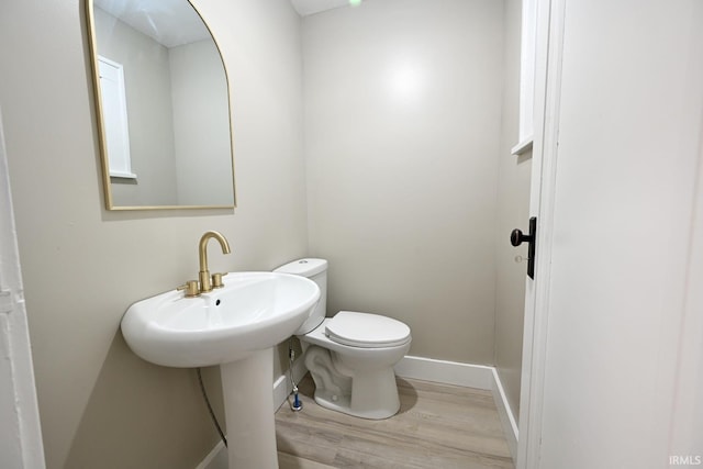 bathroom featuring wood-type flooring and toilet