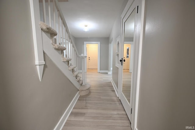 hallway with light hardwood / wood-style floors