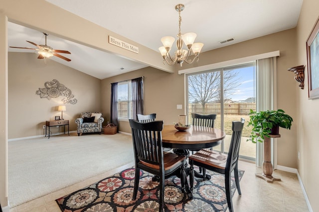 carpeted dining room featuring vaulted ceiling and ceiling fan with notable chandelier