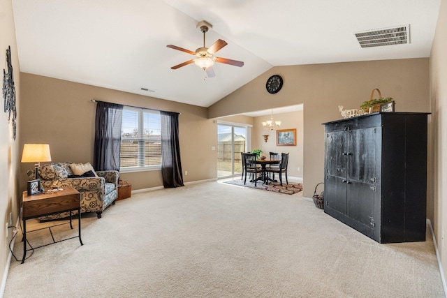 living area with lofted ceiling, ceiling fan with notable chandelier, and carpet