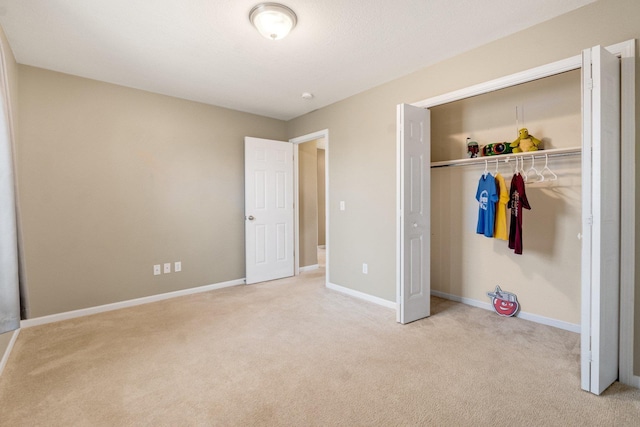 unfurnished bedroom with light colored carpet and a closet