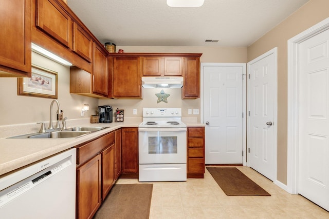 kitchen with sink, a textured ceiling, and white appliances