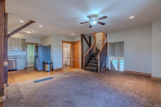 unfurnished living room with ceiling fan and light colored carpet