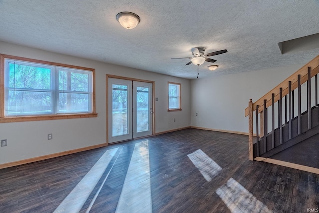 empty room featuring dark wood-type flooring, ceiling fan, and a textured ceiling