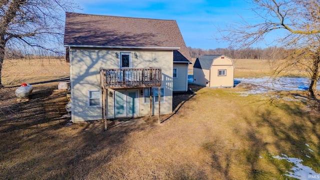 back of property with a yard, a deck, and a storage unit