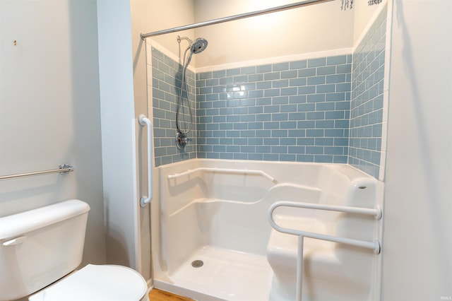 bathroom with a tile shower and toilet