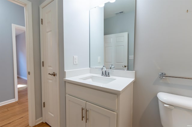 bathroom with vanity, wood-type flooring, and toilet