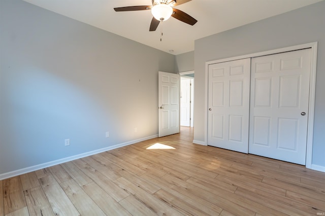 unfurnished bedroom featuring ceiling fan, light wood-type flooring, and a closet