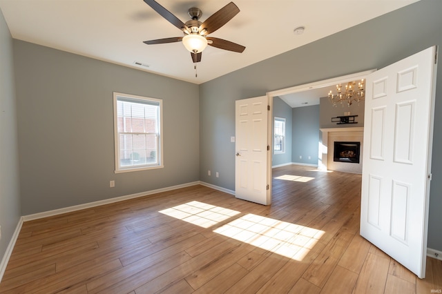 spare room featuring ceiling fan, a healthy amount of sunlight, and light hardwood / wood-style floors