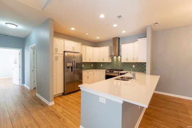 kitchen featuring wall chimney exhaust hood, stainless steel appliances, sink, and white cabinets