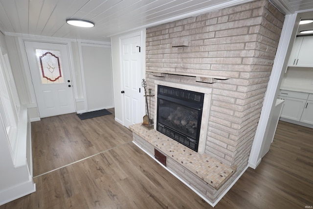 unfurnished living room with a brick fireplace and light hardwood / wood-style flooring