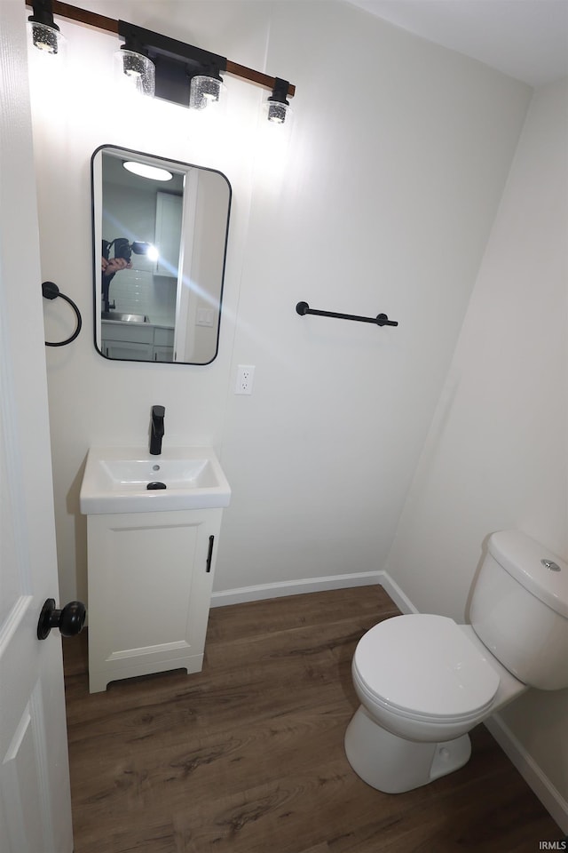 bathroom with vanity, wood-type flooring, and toilet