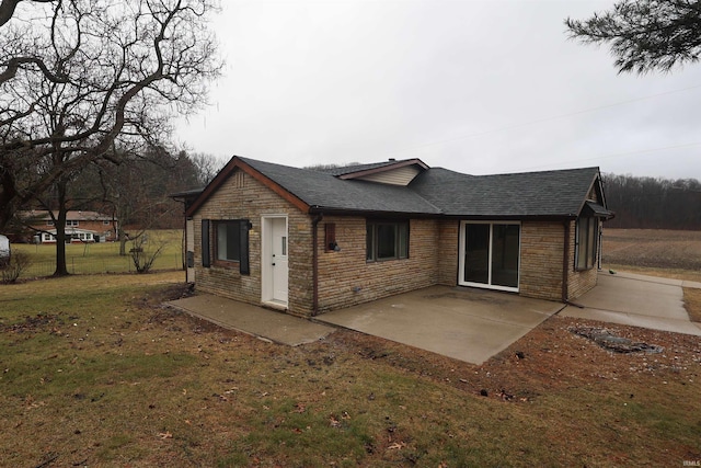 back of property featuring a patio area and a lawn