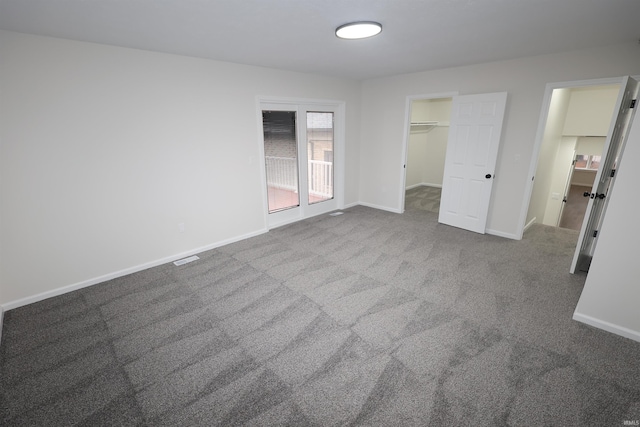 unfurnished bedroom with carpet flooring and a spacious closet