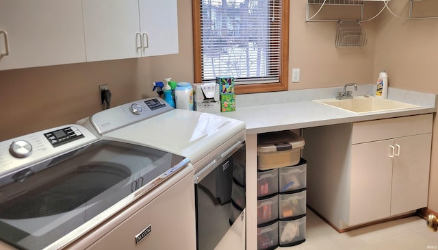 laundry area featuring sink, washer and clothes dryer, and cabinets