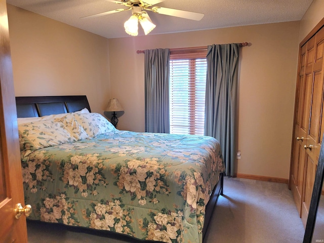 bedroom with ceiling fan, a closet, carpet, and a textured ceiling