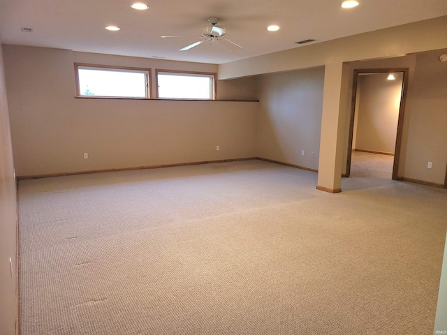 basement featuring light colored carpet and ceiling fan