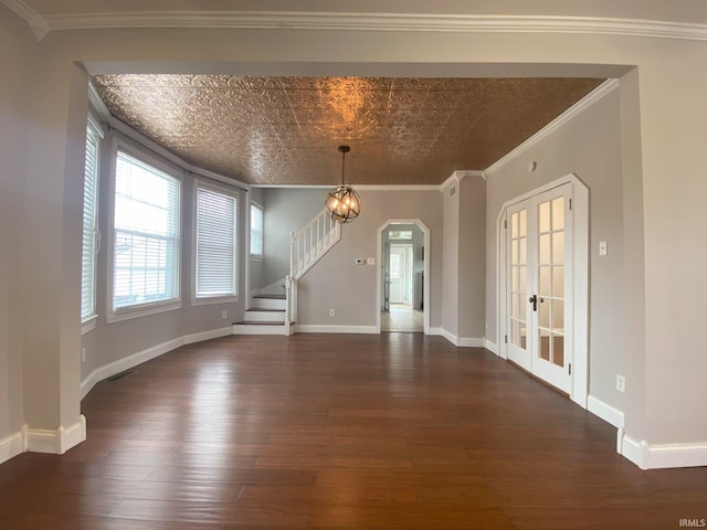 unfurnished dining area featuring dark hardwood / wood-style flooring, ornamental molding, and an inviting chandelier