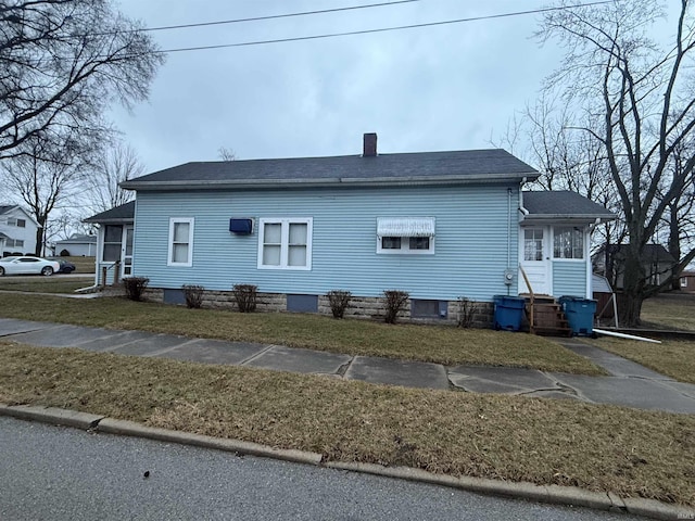 view of side of home with a lawn and a sunroom