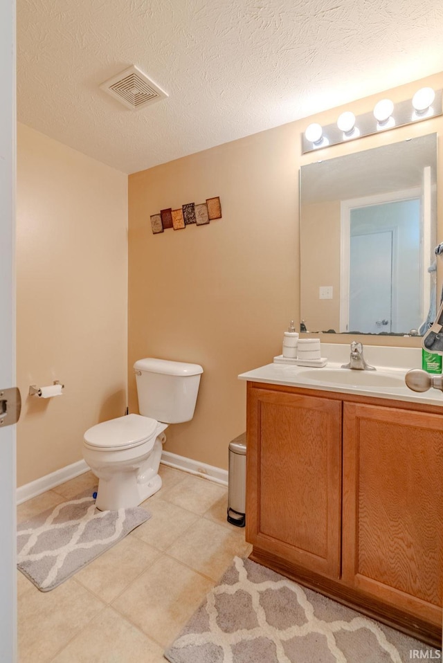 bathroom featuring vanity, a textured ceiling, and toilet