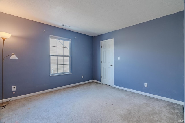 unfurnished room featuring carpet floors and a textured ceiling