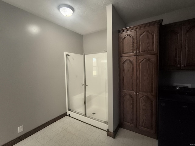 bathroom featuring a shower with door and a textured ceiling