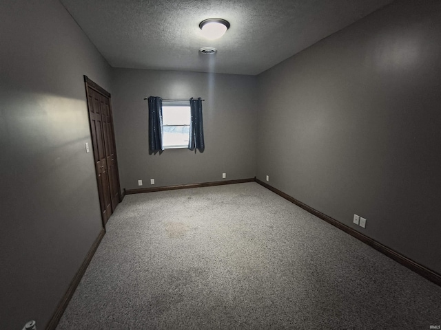 empty room featuring a textured ceiling and carpet flooring