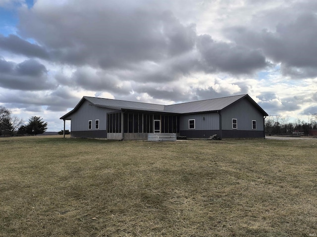 back of property with a sunroom and a lawn