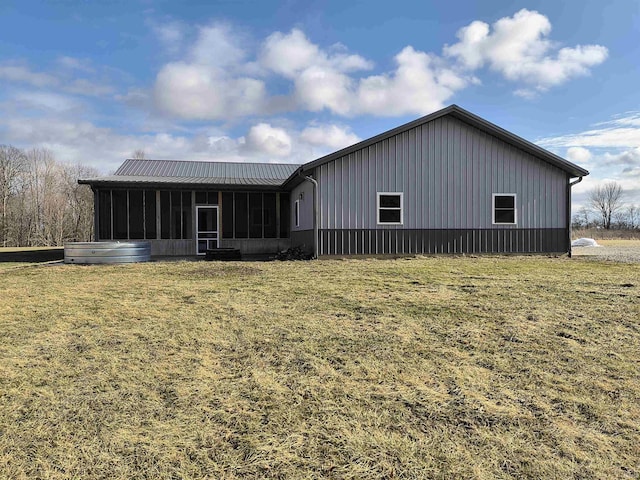 back of house featuring a yard and a sunroom