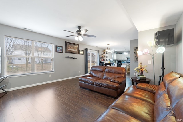 living room featuring dark wood-type flooring and ceiling fan