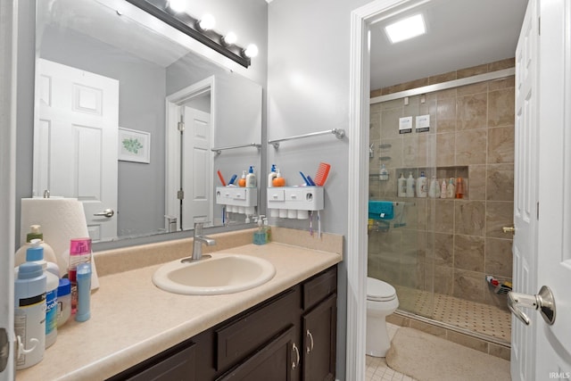 bathroom with vanity, a shower with door, and toilet