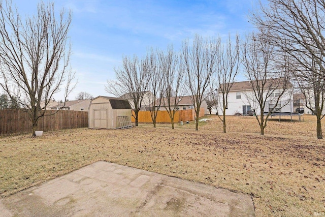 view of yard featuring a patio, a trampoline, and a storage shed