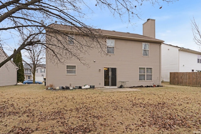 rear view of property featuring a yard and a patio area