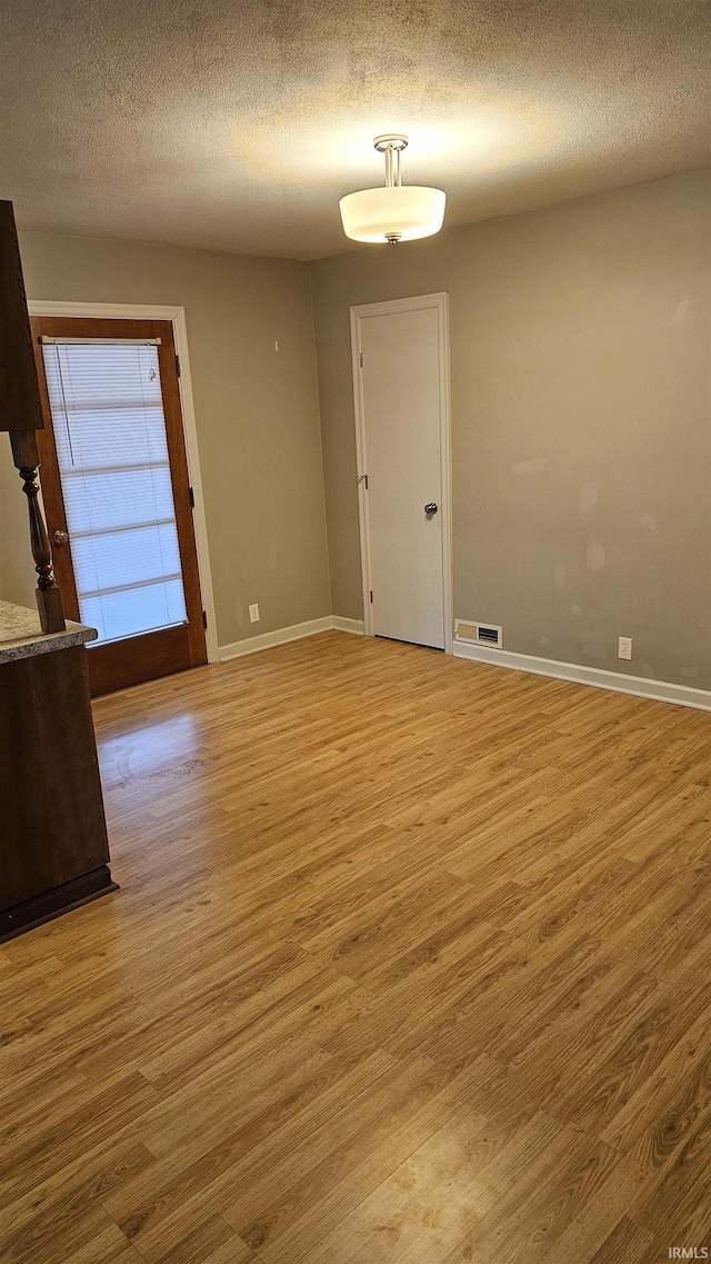 empty room featuring hardwood / wood-style floors and a textured ceiling